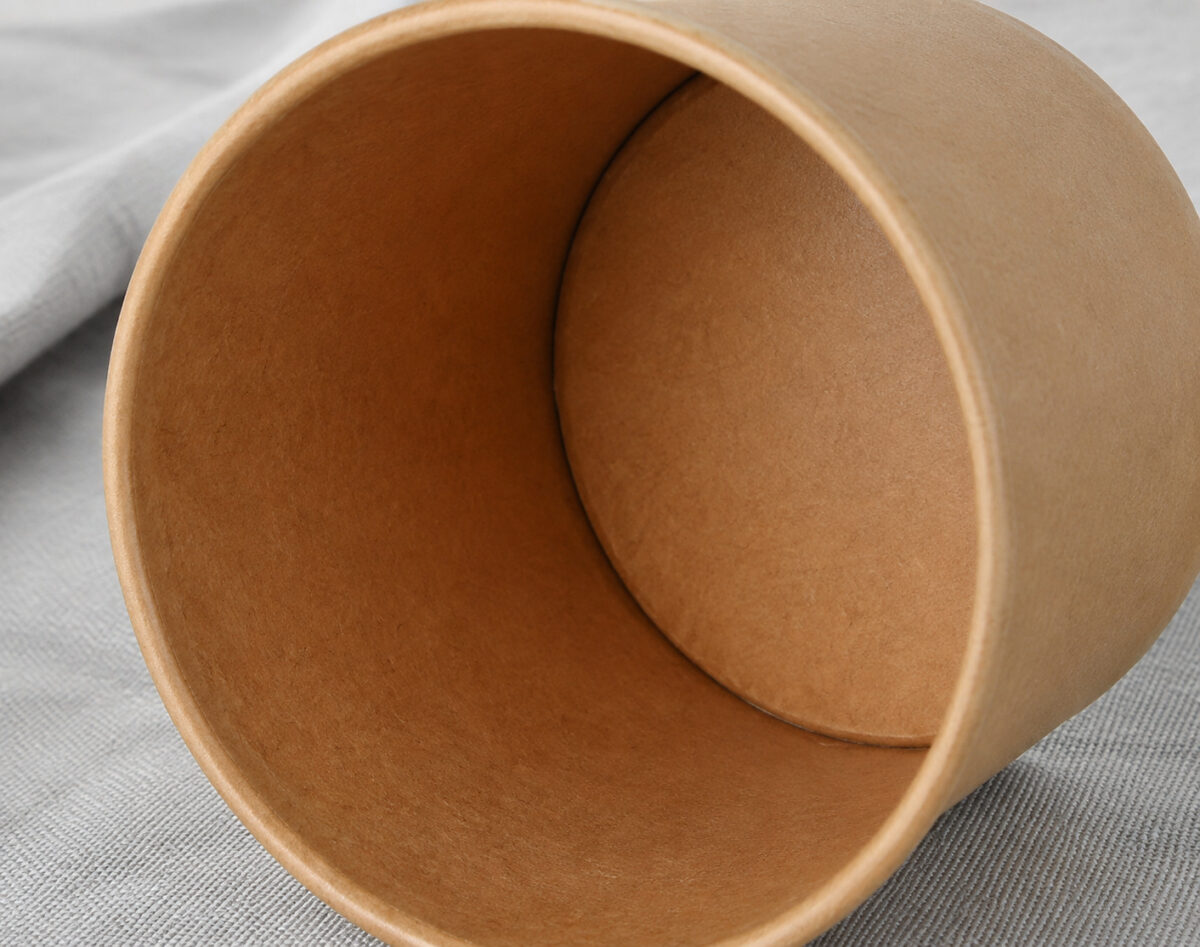 Inside of a kraft paper food tub showing its brown closed base, seam and rolled rim