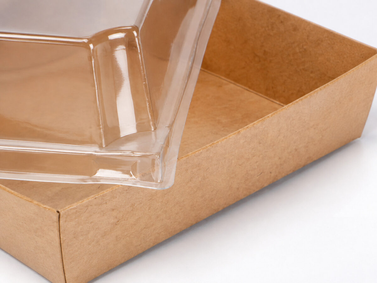 Close-up of the molded clear lid corner and folded kraft paper dessert tray