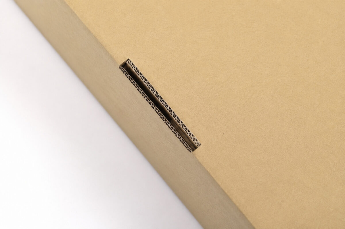 Close-up of a narrow locking slot and corrugated edges in a kraft box panel