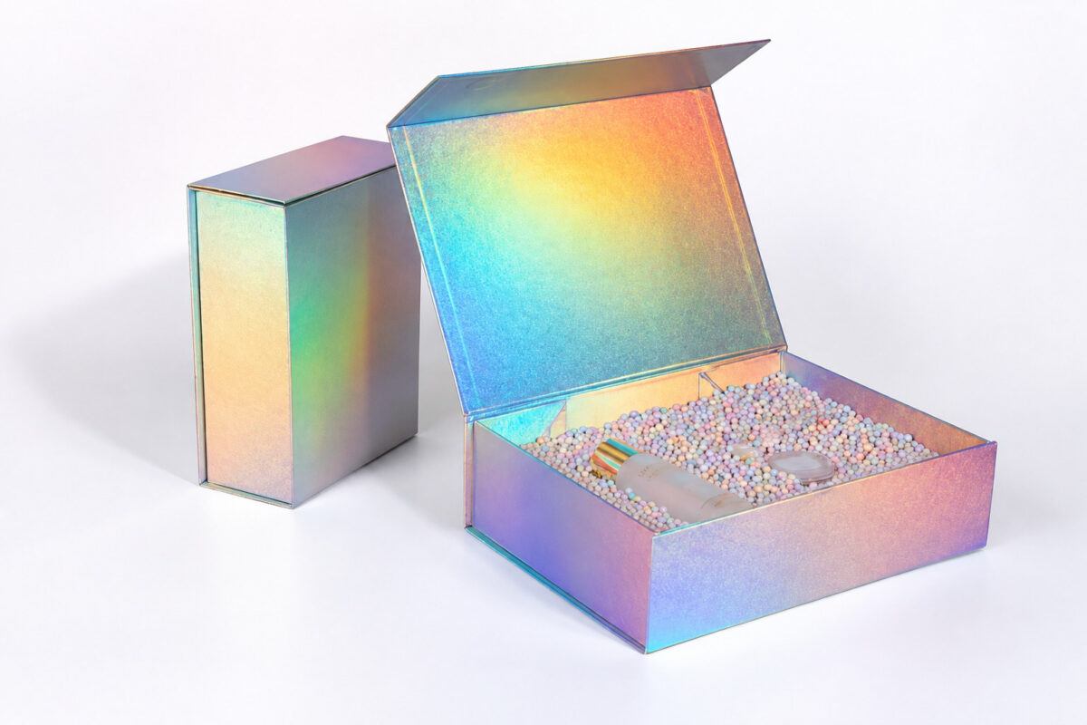 Open and closed iridescent folding gift boxes with pastel filler and cosmetic containers