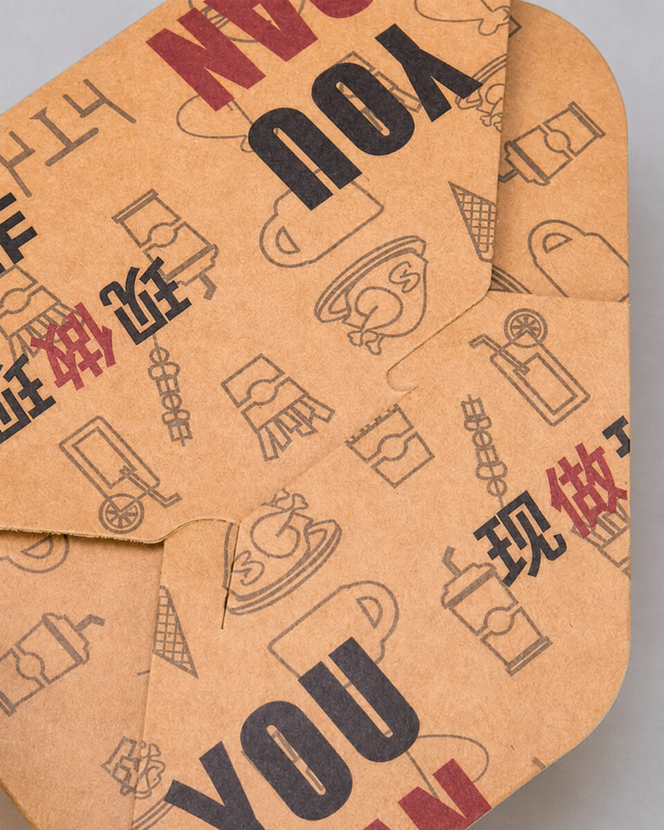 Interlocking flap detail on a kraft carton with food illustrations