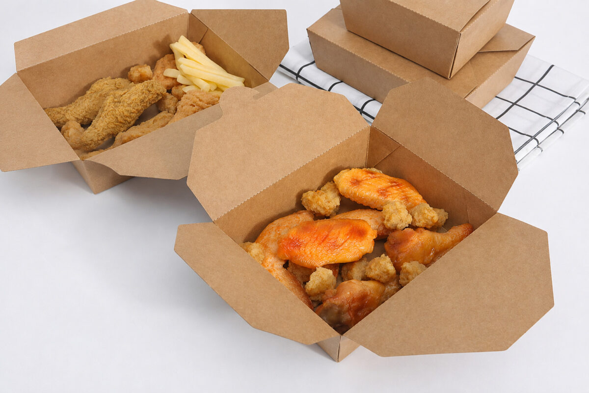 Two open kraft food cartons with chicken and fries beside two stacked closed cartons
