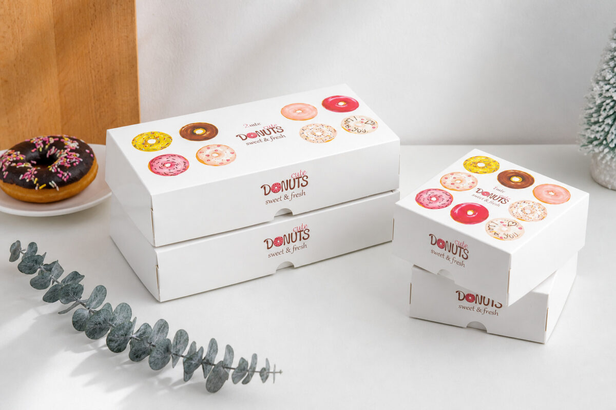 Four white donut boxes in two sizes with colorful donut illustrations