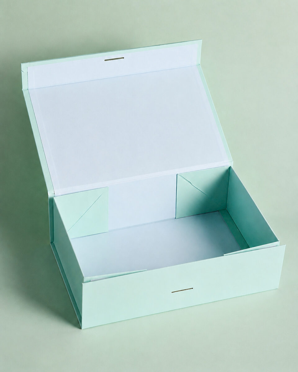 Open mint green folding ribbon gift box showing its attached lid, corner folds and closure slots