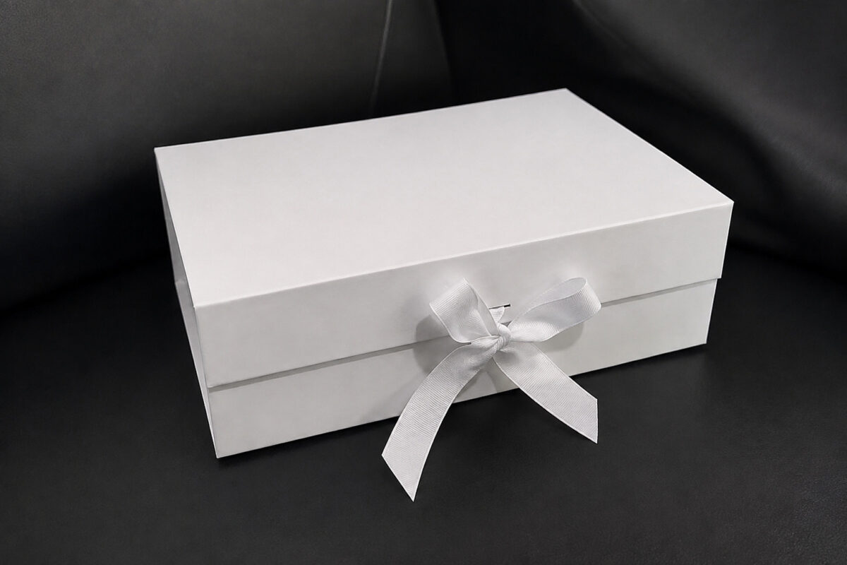 White ribbon gift box on a dark tabletop