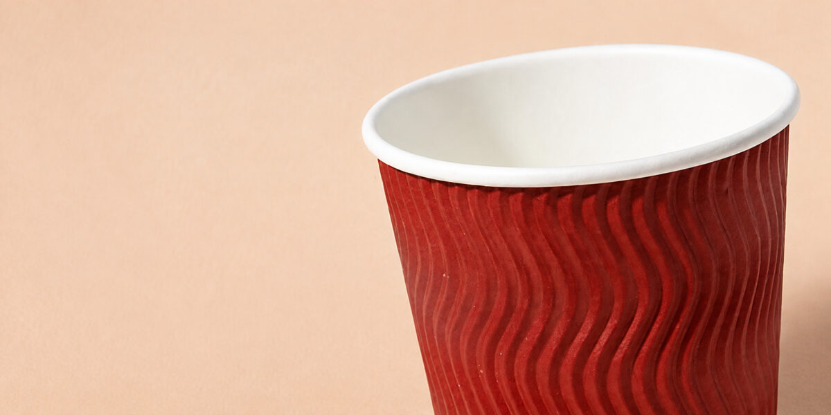 Close-up of the white rolled rim and red ripple paper wall of a coffee cup