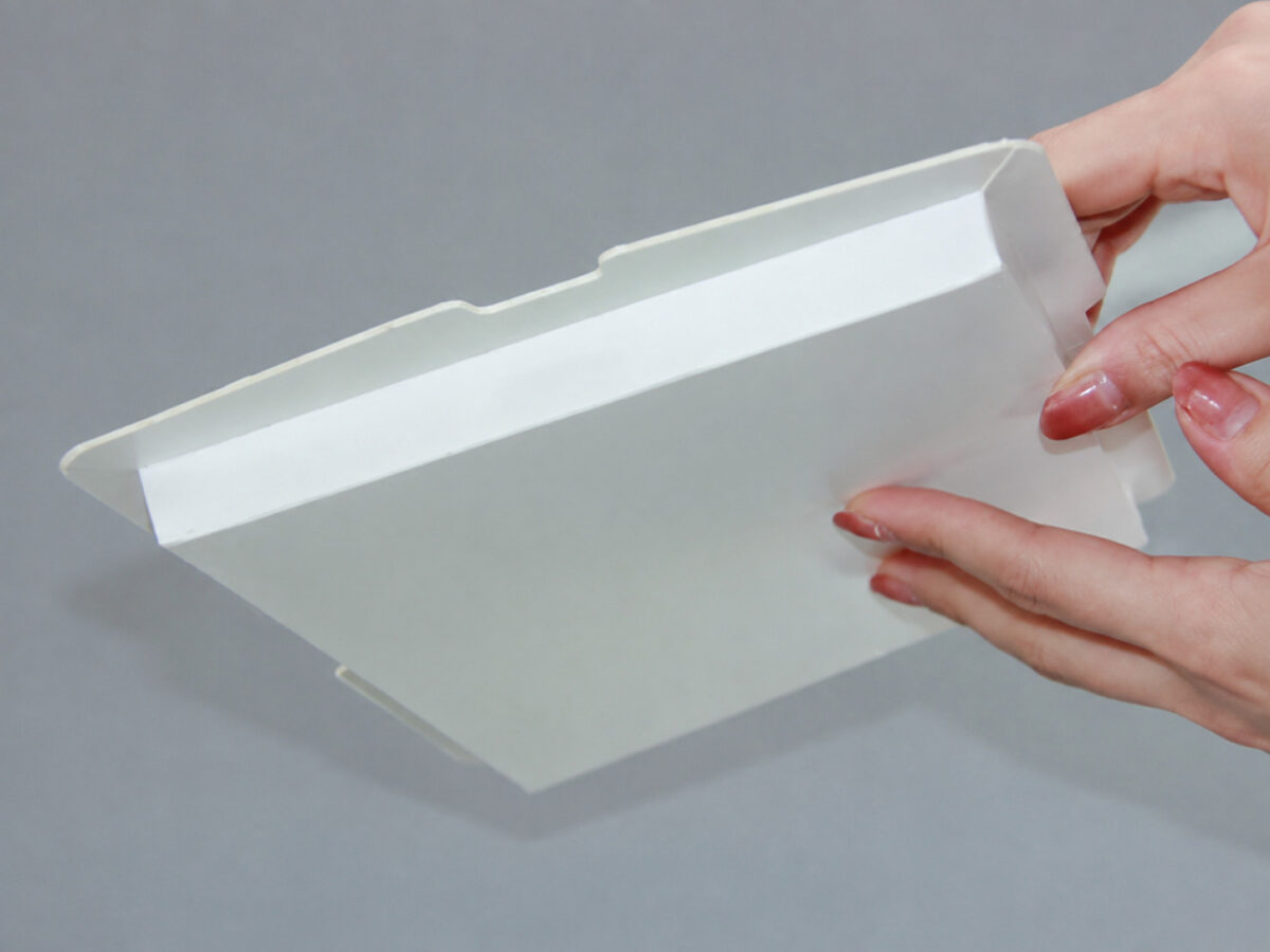 Hands folding a shallow white paperboard cake box component
