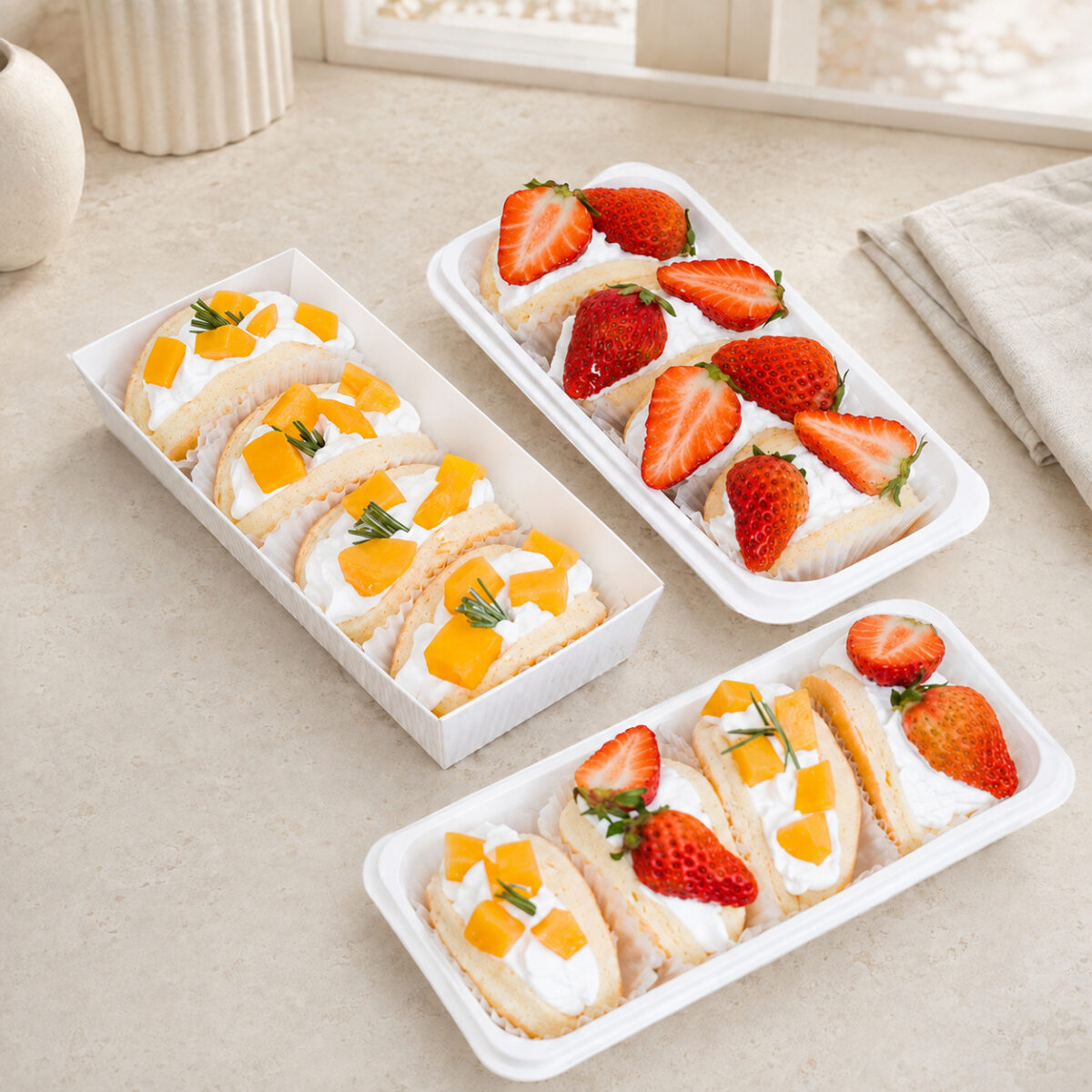 White Paper Trays for Fruit Desserts Three white dessert trays holding mango and strawberry cream portions, with one rectangular paper tray and two rounded trays