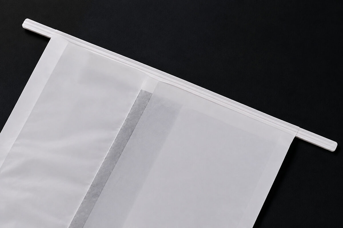 Close-up of the folded top closure of a white paper bread bag