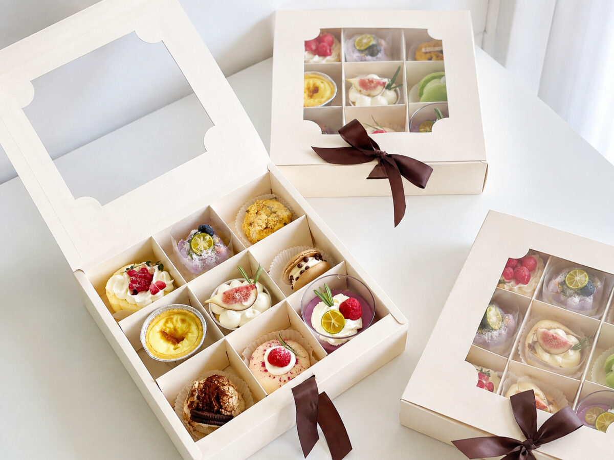 White nine-compartment pastry gift boxes with clear windows and brown ribbons